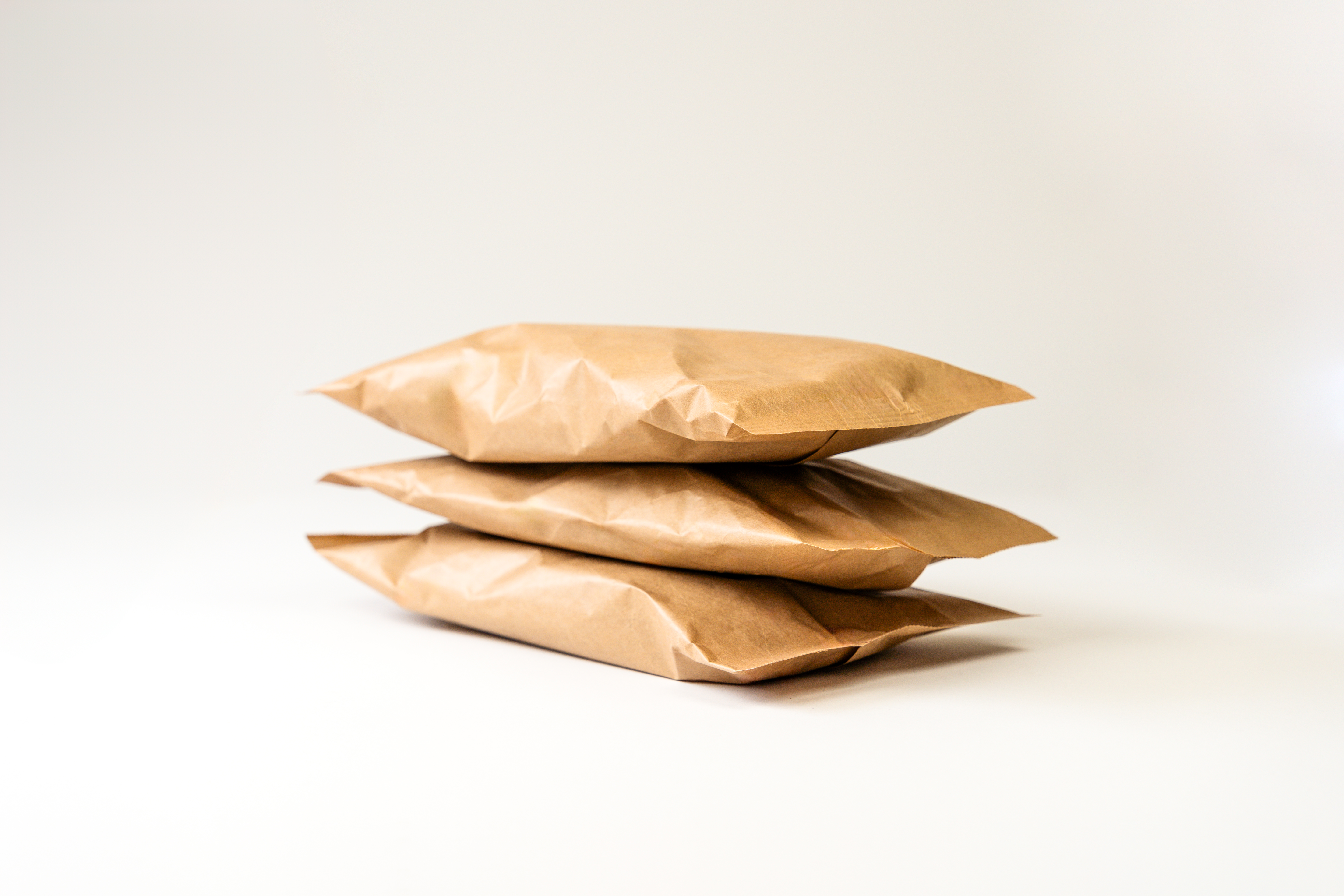 Ansicht von schräg vorn auf drei übereinander liegende Taschen Füllmaterial aus braunem Papier.