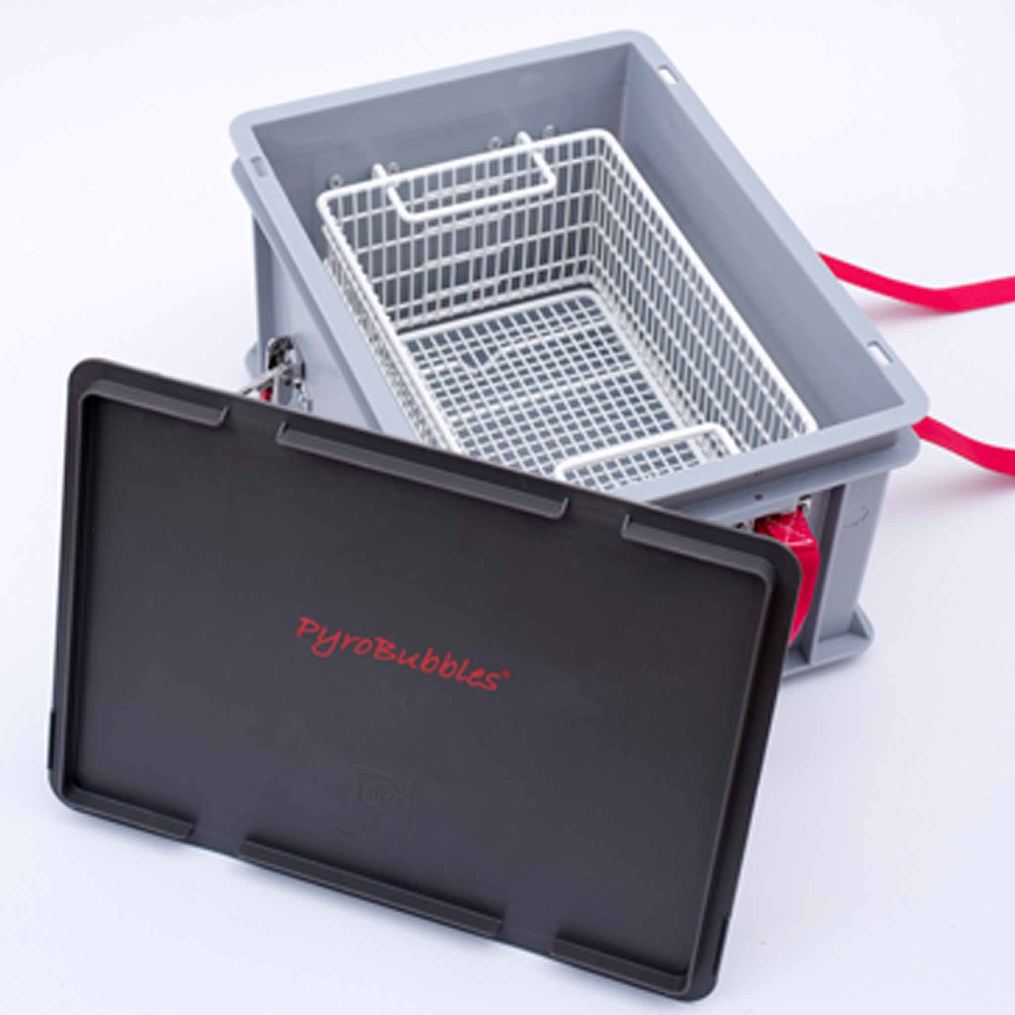 XS-Box 1 Advanced Ansicht von schräg oben auf eine graue Kunststoffbox mit weißem Korb zur Produktaufnahme. Vor der Box steht ein schwarzer Deckel